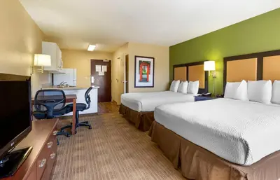 a hotel room with two beds and a desk at Extended Stay America Suites - Orlando - Maitland - 1776 Pembrook Dr in Orlando
