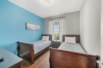 two beds in a room with blue walls at Deluxe 3 Bedroom Apartment 404 in Orlando