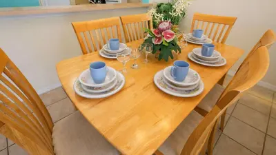 a wooden table with plates and cups on it at The Floridian 3 bed townhouse at Emerald Island Resort in Kissimmee