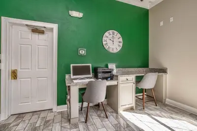 a room with a desk with a computer and a clock at The Floridian 3 bed townhouse at Emerald Island Resort in Kissimmee