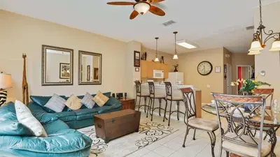 a living room with a blue couch and a kitchen at Minnies Townhouse in Windsor Palms Resort in Kissimmee