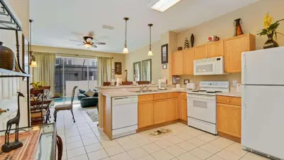 a kitchen with white appliances and a living room at Minnies Townhouse in Windsor Palms Resort in Kissimmee