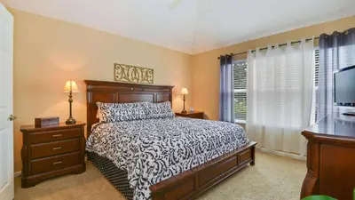a bedroom with a bed and a flat screen tv at Minnies Townhouse in Windsor Palms Resort in Kissimmee