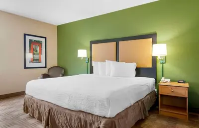 a large bed in a hotel room with green walls at Extended Stay America Select Suites - Orlando - Southpark - Equity Row in Orlando