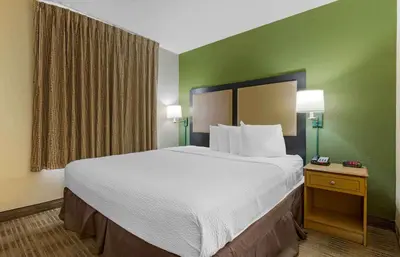 a large bed in a hotel room with green walls at Extended Stay America Select Suites - Orlando - Southpark - Equity Row in Orlando