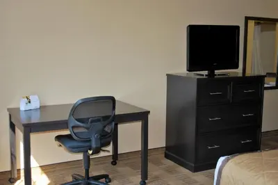 a bedroom with a desk and a television and a chair at Extended Stay America Select Suites - Orlando - Southpark - Equity Row in Orlando