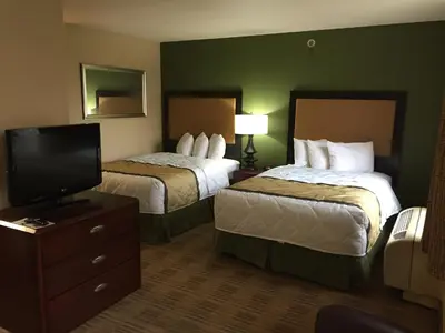a hotel room with two beds and a flat screen tv at Extended Stay America Select Suites - Orlando - Maitland - Summit Tower Blvd in Orlando