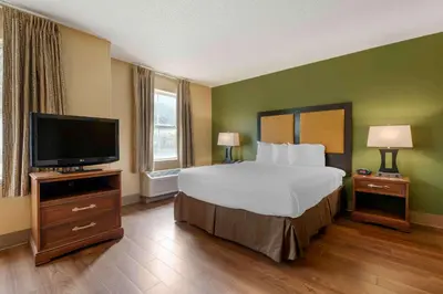 a hotel room with a bed and a flat screen tv at Extended Stay America Suites - Orlando - Convention Center - 6443 Westwood in Orlando