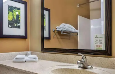 a bathroom with a sink with a mirror and towels at Extended Stay America Suites - Orlando - Convention Center - 6443 Westwood in Orlando