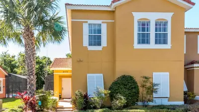 a house with a palm tree in front of it at Bikini on the Beach at Terra Verde Resort in Kissimmee