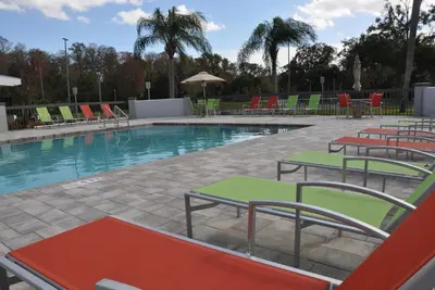 a swimming pool with colorful chairs and tables at Nobile Hotel Parkway at Celebration Orlando Very Close to Disney Theme Parks in Orlando