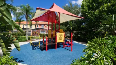 a playground with a umbrella on top at Encantada Rose - a 4 bed townhouse near Disney in Kissimmee
