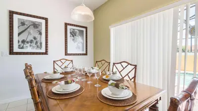 a dining room with a wooden table with chairs at Encantada Rose - a 4 bed townhouse near Disney in Kissimmee