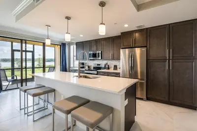 a kitchen with a large white island with bar stools at Siena at Bella Collina in Montverde