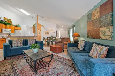 a living room with a blue couch and a table at Castaway Getaway - Very popular 4 bed family pool home on Terra Verde Resort - close to Disney World in Kissimmee