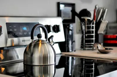 a tea kettle sitting on top of a stove at Sunshine Station - Spacious 4 bed Windsor Palms resort home that's close to Disney in Kissimmee