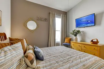 a bedroom with a bed and a dresser and a mirror at Sunshine Station - Spacious 4 bed Windsor Palms resort home that's close to Disney in Kissimmee