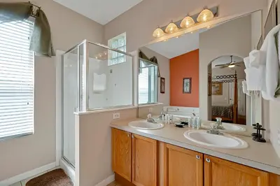 a bathroom with two sinks and a large mirror at Disney Magic Vacation - A fabulous 4 bed family pool home on Windsor Palms Resort - close to Disney World in Kissimmee