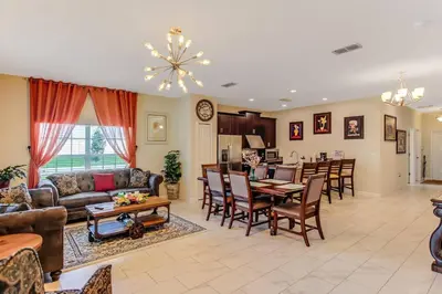 a living room with a couch and a table at G - New 5 Bedroom Home - 5 Miles to Disney - Free Water Park - Private Pool in Kissimmee