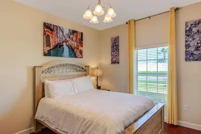 a bedroom with a bed and a large window at G - New 5 Bedroom Home - 5 Miles to Disney - Free Water Park - Private Pool in Kissimmee