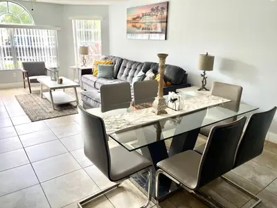 a living room with a glass table and a couch at Great Lovely Family Apartment close Disney in Kissimmee