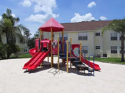 a playground in the sand in front of a building at Great Lovely Family Apartment close Disney in Kissimmee