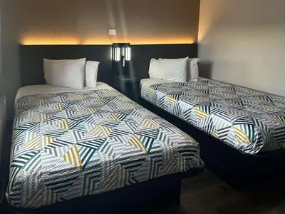 two beds sitting next to each other in a room at Motel 6-Kissimmee, FL - Orlando in Orlando