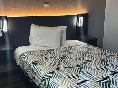 a bedroom with a bed with a black headboard at Motel 6-Kissimmee, FL - Orlando in Orlando