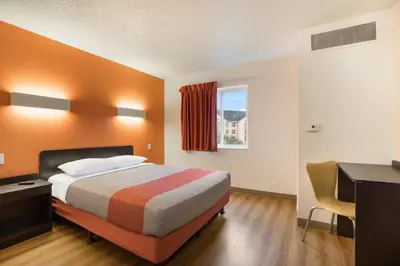 a bedroom with a bed and a desk and a window at Motel 6-Orlando, FL - International Dr in Orlando