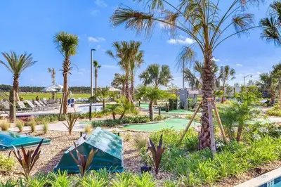 a golf course with palm trees in a resort at F - New 4 Bedroom Home - 5 Miles to Disney - Free Water Park - Private Pool in Kissimmee