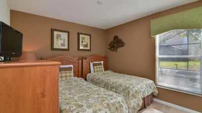 a bedroom with a bed and a flat screen tv at Shooting Star - Family friendly 4 bed pool home on Emerald Island Resort - close to Disney World! in Kissimmee