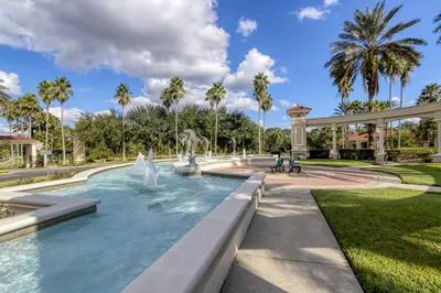 a fountain in a park with palm trees at Shooting Star - Family friendly 4 bed pool home on Emerald Island Resort - close to Disney World! in Kissimmee