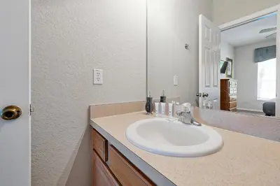 a bathroom with a white sink and a mirror at Mickey's Ranch - 4 bed pool home - Windsor Hills in Orlando