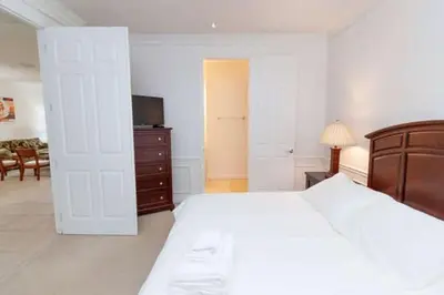 a bedroom with a large white bed and a television at 5min Universal Spacious Condo VC101 in Orlando