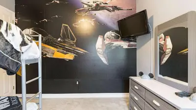 a bedroom with a black wall with a spaceship mural at Closest to Disney in Orlando