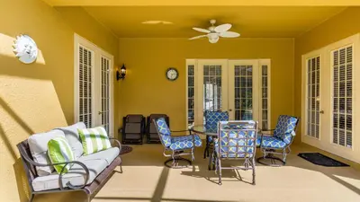 a living room with chairs and a couch and a clock at Closest to Disney in Orlando
