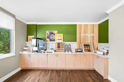 a coffee shop with green walls and a counter at Spark by Hilton Orlando near Universal in Orlando
