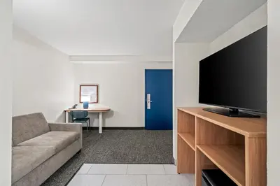 a living room with a couch and a flat screen tv at Spark by Hilton Orlando near Universal in Orlando