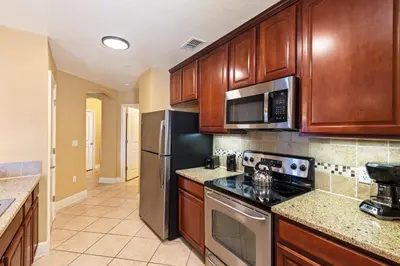 a kitchen with wooden cabinets and stainless steel appliances at The Berkley, Orlando in Orlando