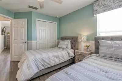 two beds in a bedroom with green walls at Disney Daze Villa - 5 bed Windsor Hills pool home in Orlando