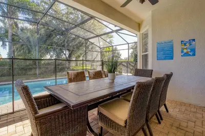 a dining room with a table and chairs and a pool at Disney Daze Villa - 5 bed Windsor Hills pool home in Orlando