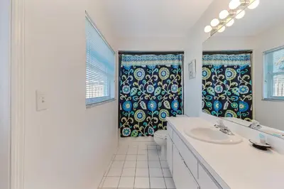 a bathroom with a sink and a toilet and a window at Quiet Home With Private Pool- Near Disney in Kissimmee