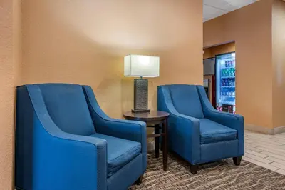 two blue chairs next to a table with a lamp at Comfort Inn & Suites Orlando North in Sanford