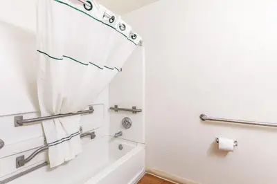 a bathroom with a tub and a shower curtain at HomeTowne Studios by Red Roof Orlando - Casselberry in Orlando