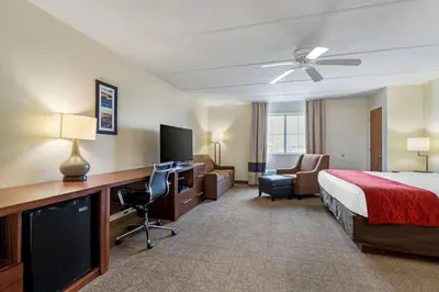 a hotel room with a bed and a desk with a computer at Comfort Inn Kissimmee-Lake Buena Vista South in Kissimmee