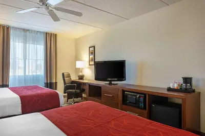 a hotel room with two beds and a flat screen tv at Comfort Inn Kissimmee-Lake Buena Vista South in Kissimmee