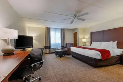 a hotel room with a bed and a desk with a television at Comfort Inn Kissimmee-Lake Buena Vista South in Kissimmee
