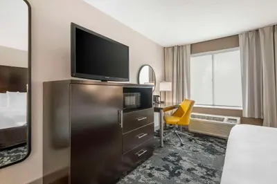 a hotel room with a television on top of a dresser at City Express by Marriott Orlando International Drive in Orlando
