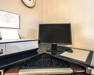 a computer with a keyboard and a mouse on a desk at Rodeway Inn Apopka South in Orlando