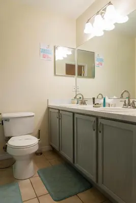 a bathroom with a toilet and a sink and a mirror at Private Pool House With Private Pool, Near All Famous Attractions!!! in Kissimmee